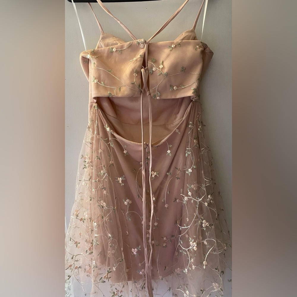 Short pink dress with lace embroidered flower detailings.